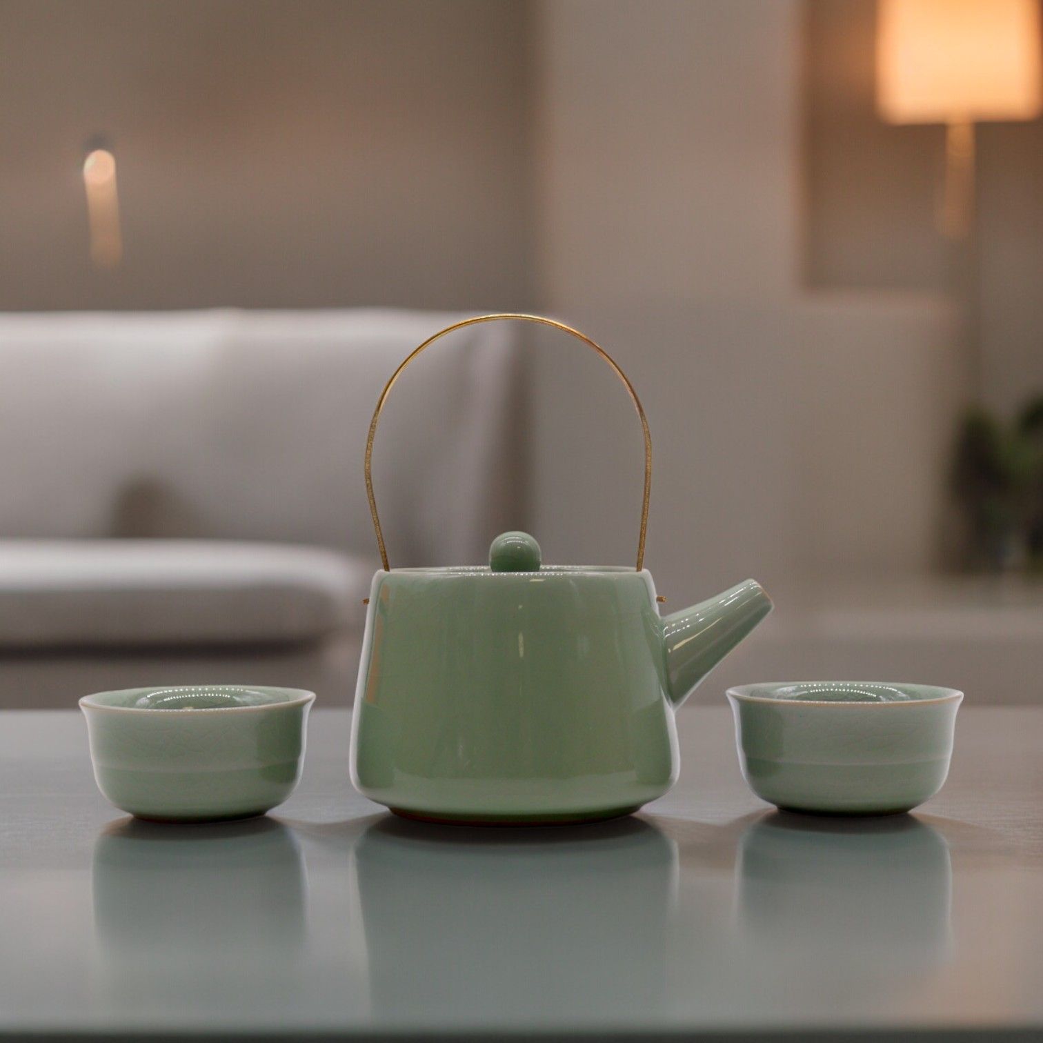 Elegant jade green ceramic teapot with two matching cups in a sleek modern design on a plain background.