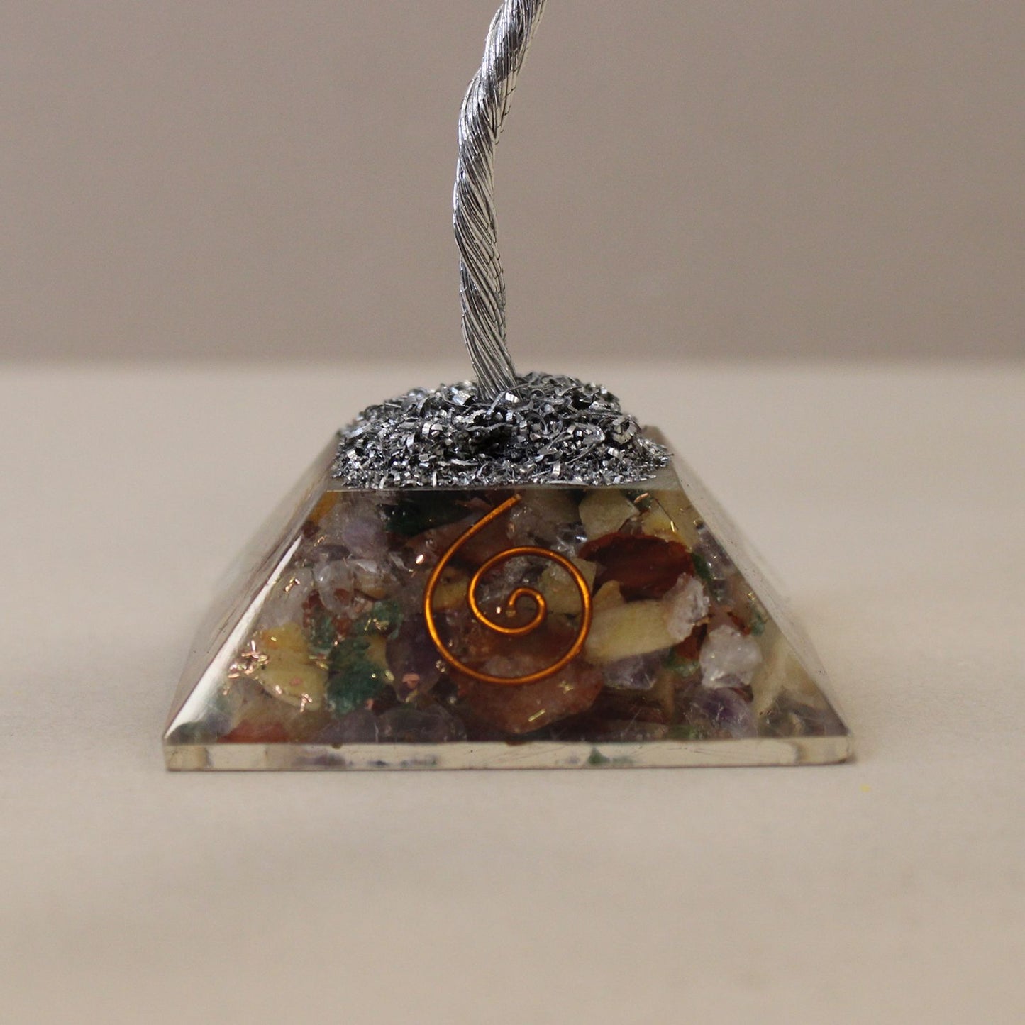Handcrafted gemstone tree with multicoloured crystals on a clear orgonite base with copper shavings.