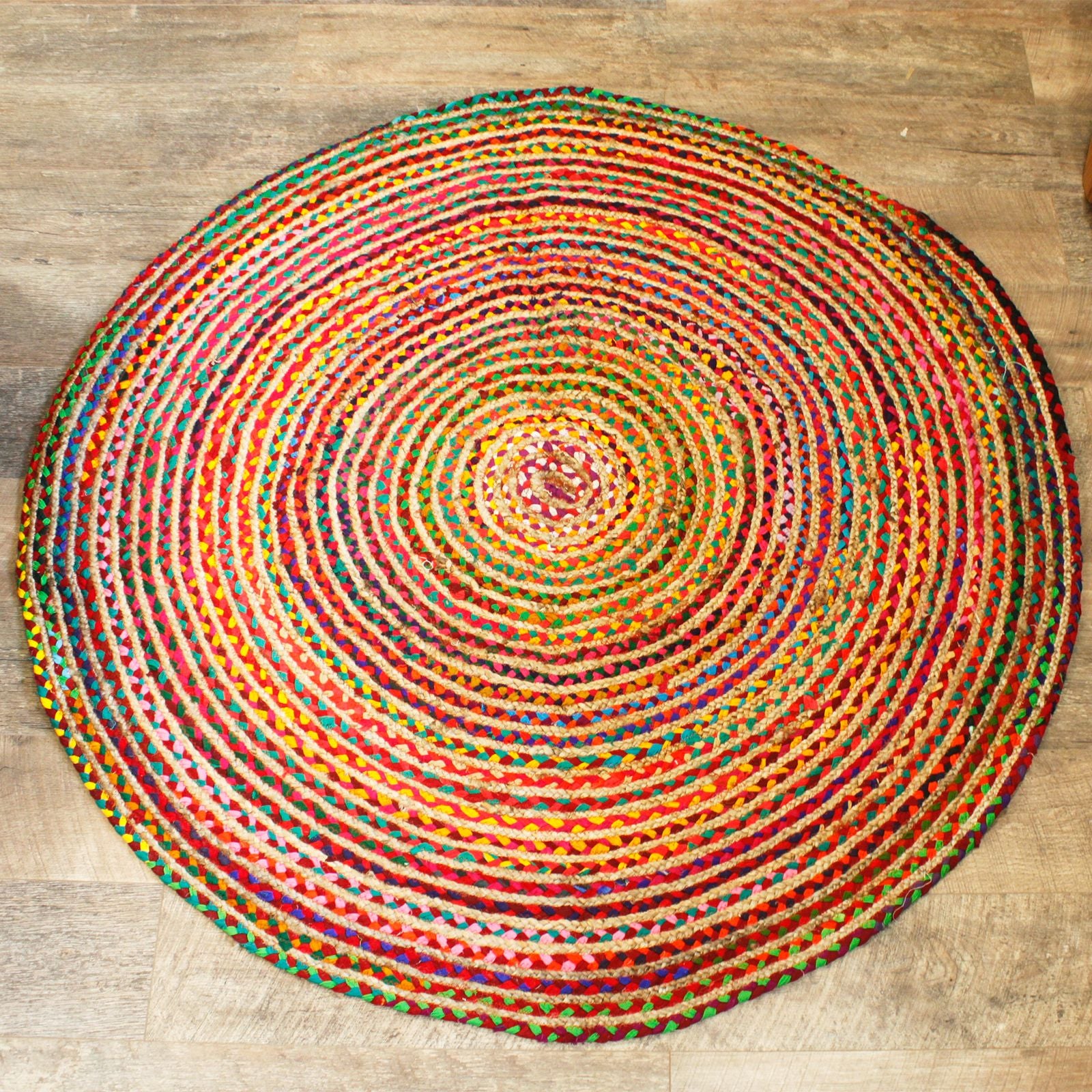 A large round rug made from natural jute fibres interwoven with colourful recycled cotton sari material.