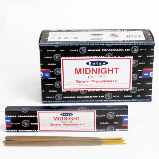 Close up of a 15 gram pack of dark blue and black incense sticks on a wooden surface.