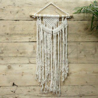Intricately handcrafted cream macrame wall hanging with a minimalist boho design and natural cotton textures.