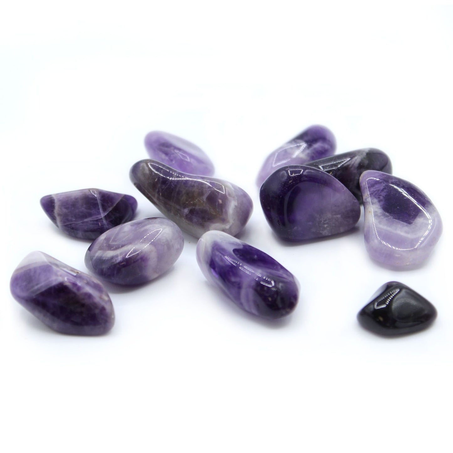 Smooth polished purple and white banded amethyst tumble stones showing unique chevron patterns.