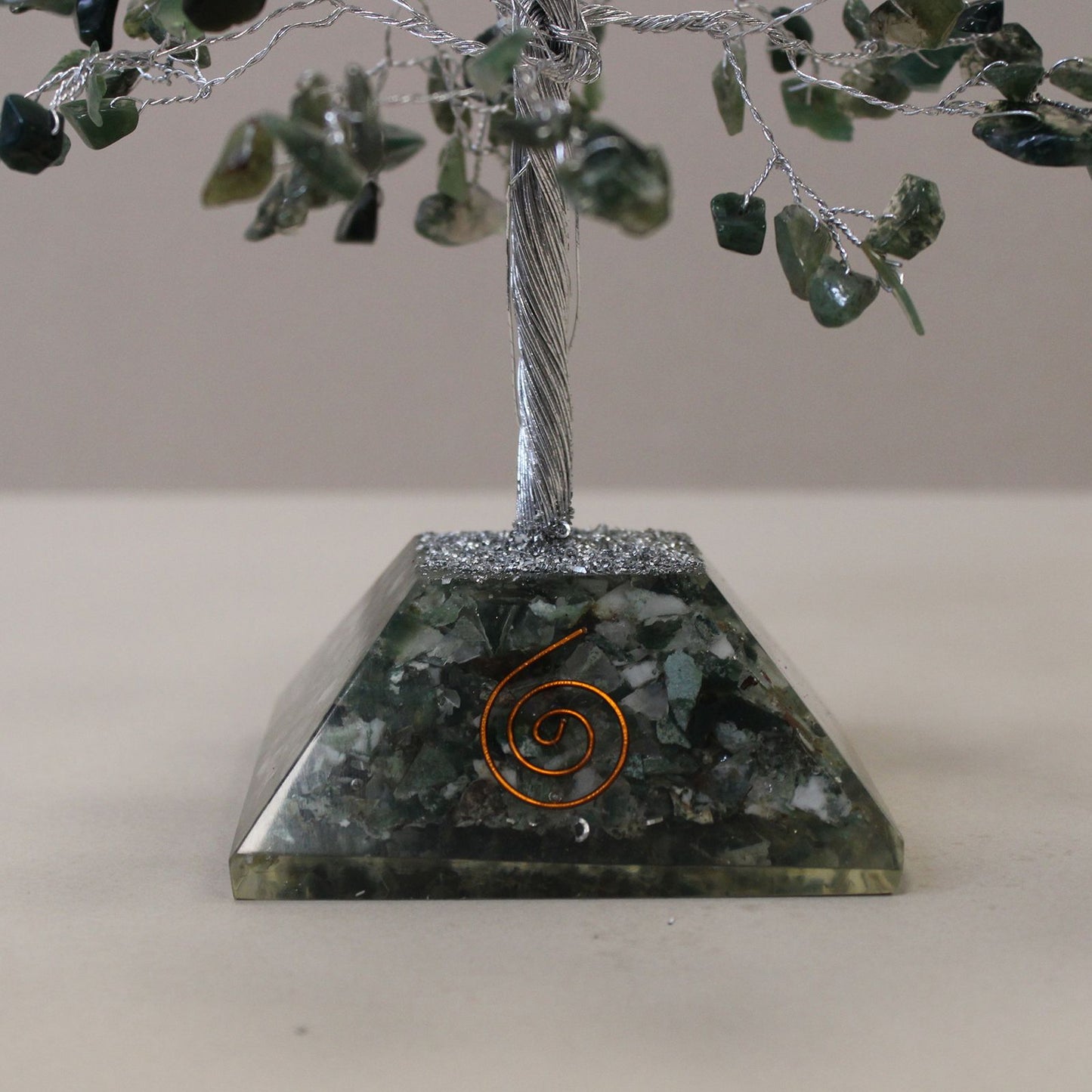 Handcrafted gemstone tree featuring green moss agate chips on silver wire branches with a pyramid-shaped orgonite base.