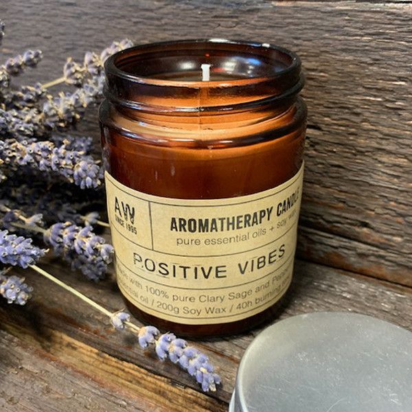 A minimalist glass jar candle featuring white soy wax and a natural wick, emitting a warm glow.