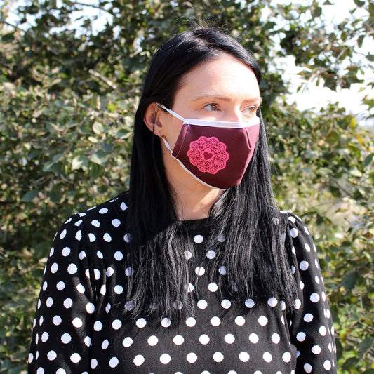 Adult-sized reusable fabric face mask featuring a vibrant red mandala heart design on a dark background.