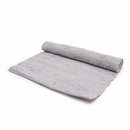 Close-up of a textured grey hand-loomed cotton rug with a classic woven pattern.