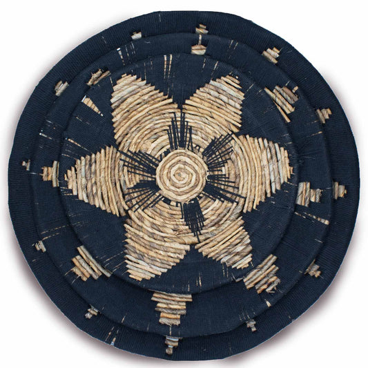 Set of three handwoven black seagrass bowls arranged as decorative wall art in a bohemian style.