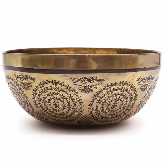 Large 21cm hand-engraved metal Tibetan singing bowl featuring intricate Om and Buddha symbols on a dark surface.