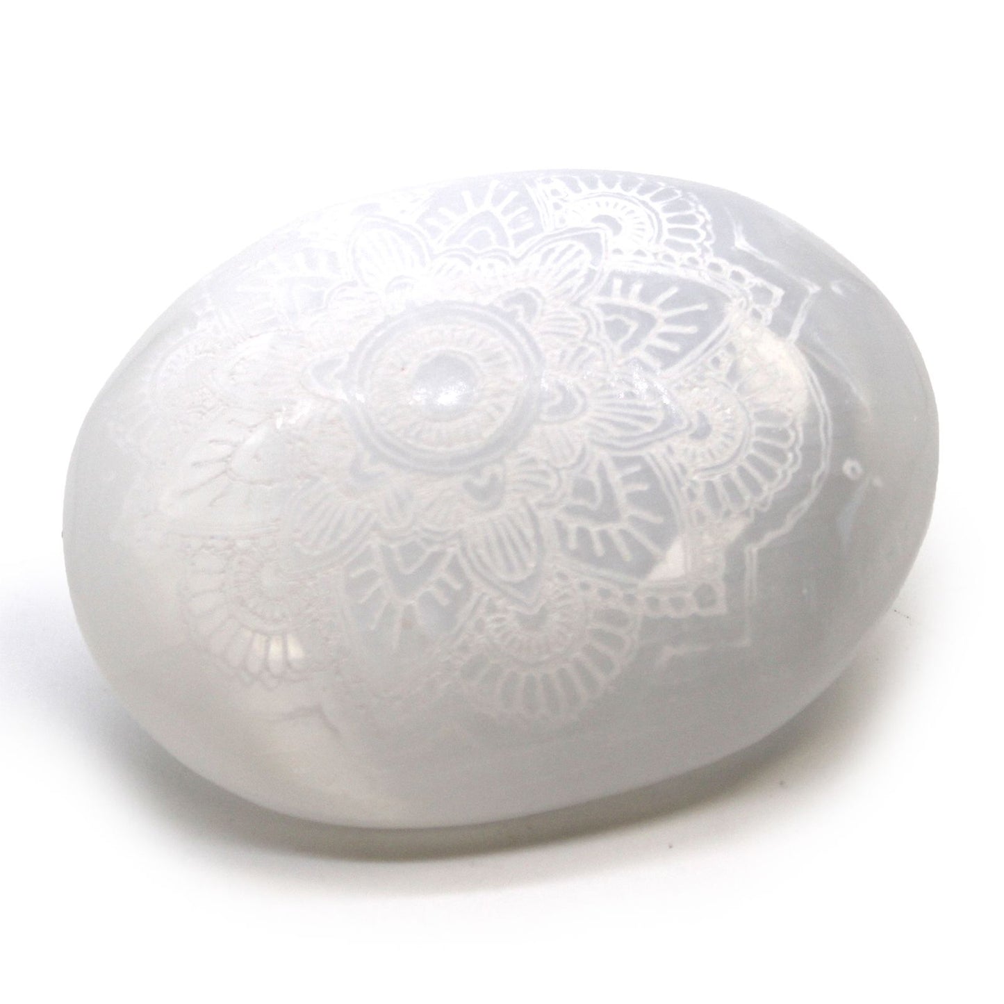Smooth white oval selenite palm stone featuring an intricate engraved mandala pattern.