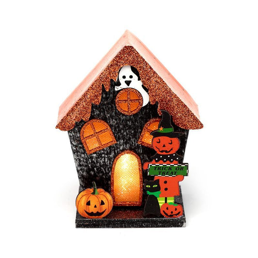 Whimsical pumpkin-shaped house decoration with cut-out windows and doors glowing with warm LED light.
