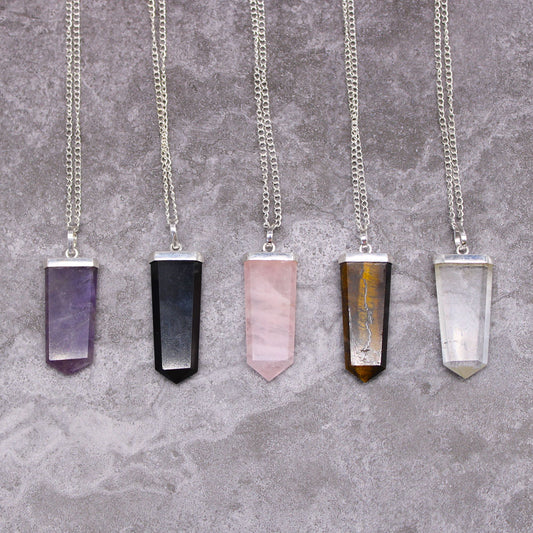 A sleek, flat pencil-shaped purple amethyst gemstone pendant with a silver-toned metal bail.