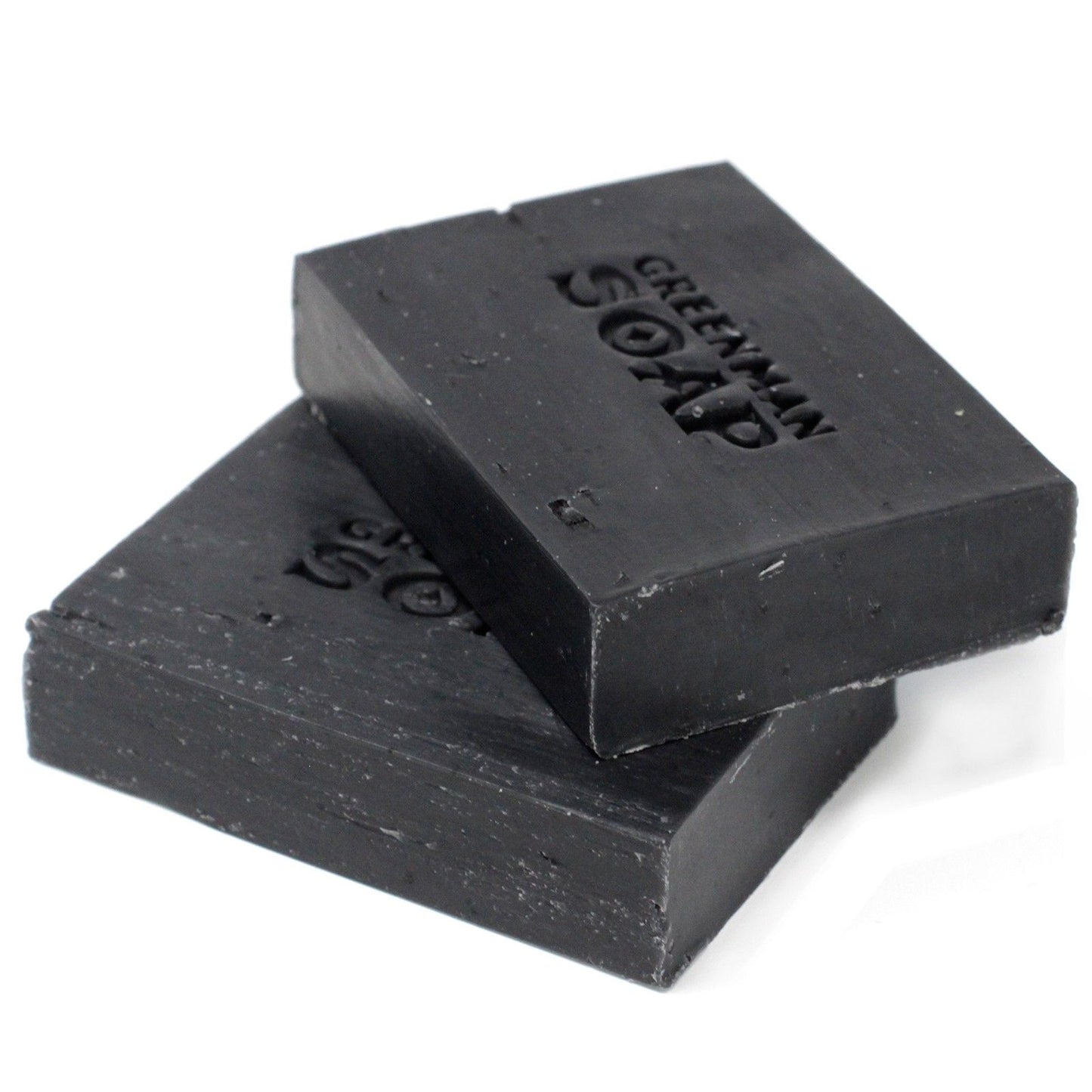 Handcrafted dark artisanal soap slice with a textured surface, containing activated charcoal, clove and sage botanicals.