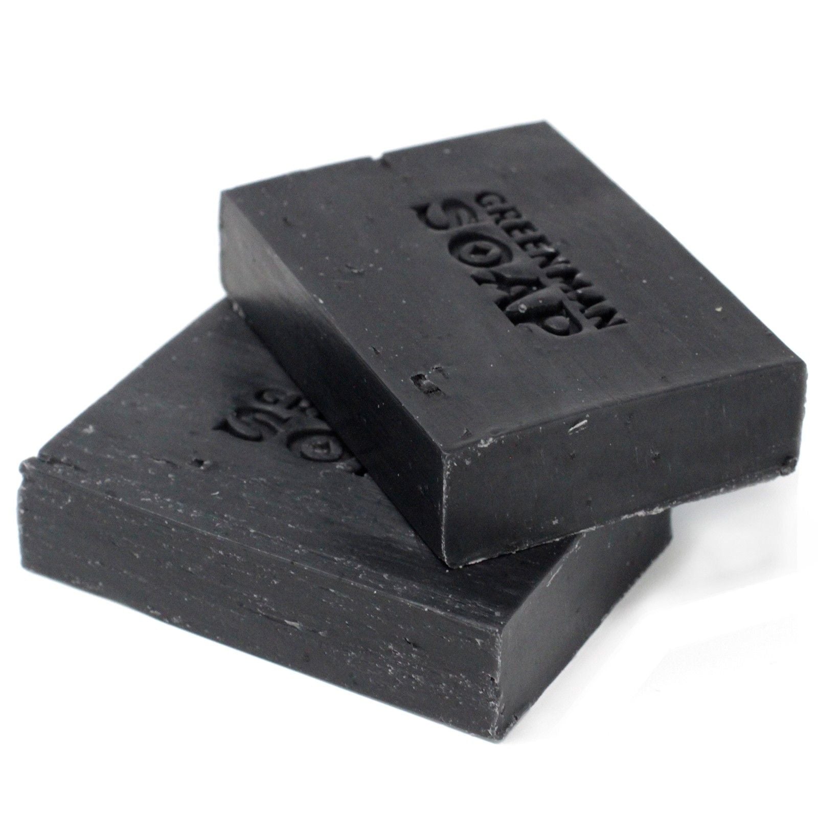 Handcrafted dark artisanal soap slice with a textured surface, containing activated charcoal, clove and sage botanicals.