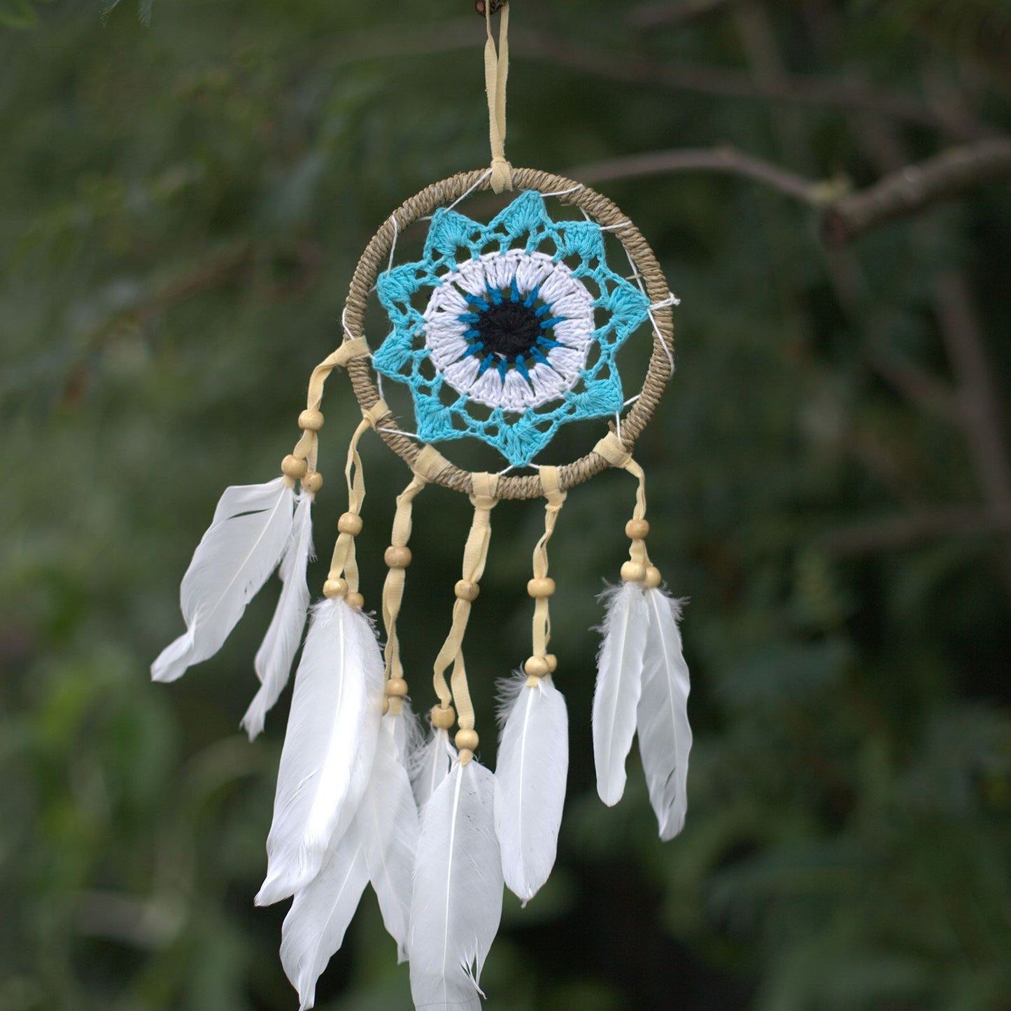 Handmade 12cm pastel blue macramé dream catcher with an intricate web design and soft cotton tassels.