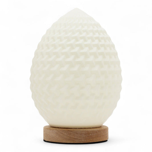 Modern teardrop-shaped lamp with a white honeycomb textured surface emitting a soft ambient glow.