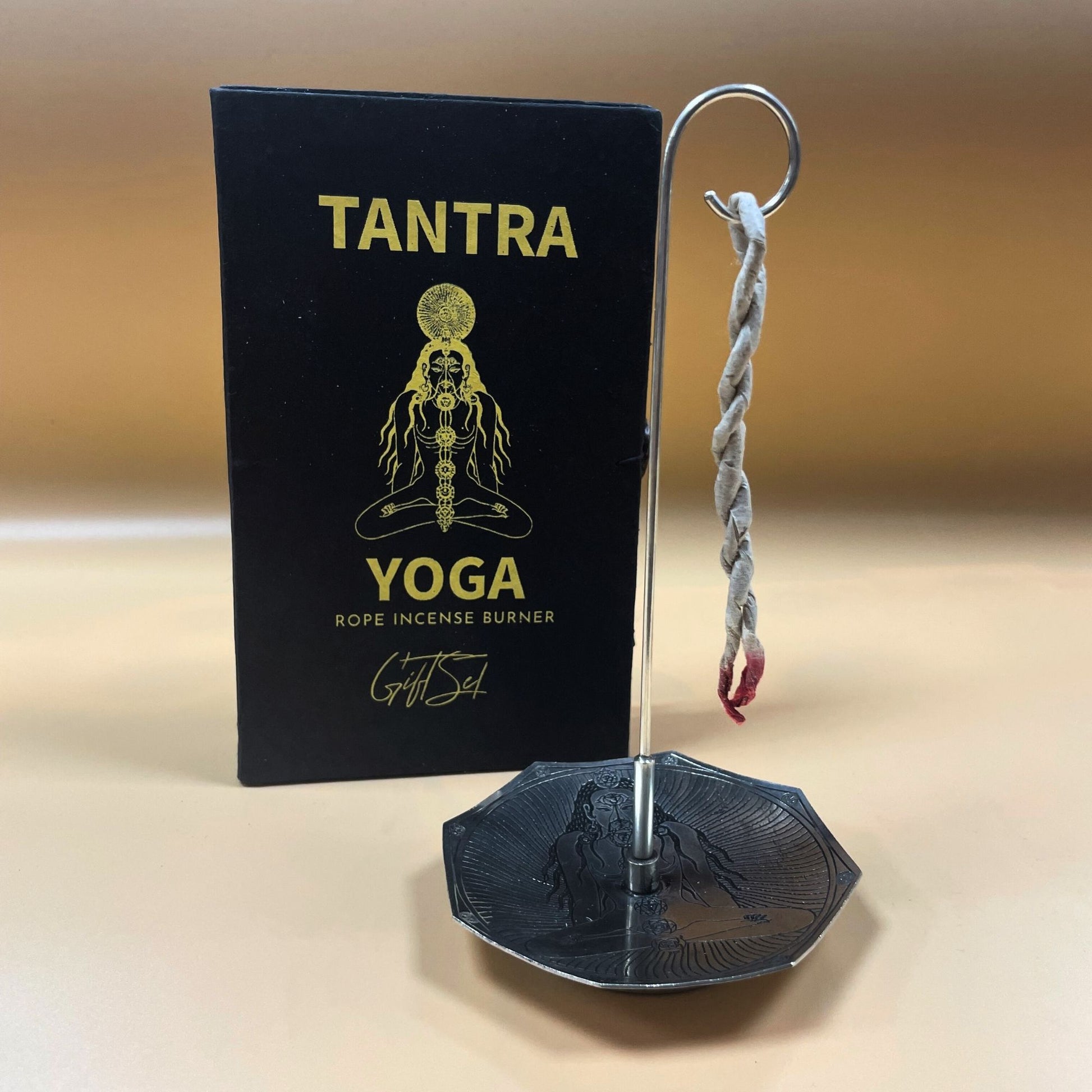 Hand-rolled rope incense bundle with a circular silver-plated holder featuring embossed seven chakra symbols.