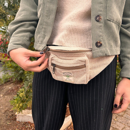 A natural beige cotton and hemp style adjustable belt bag with a zippered compartment and a minimalist eco-friendly look.