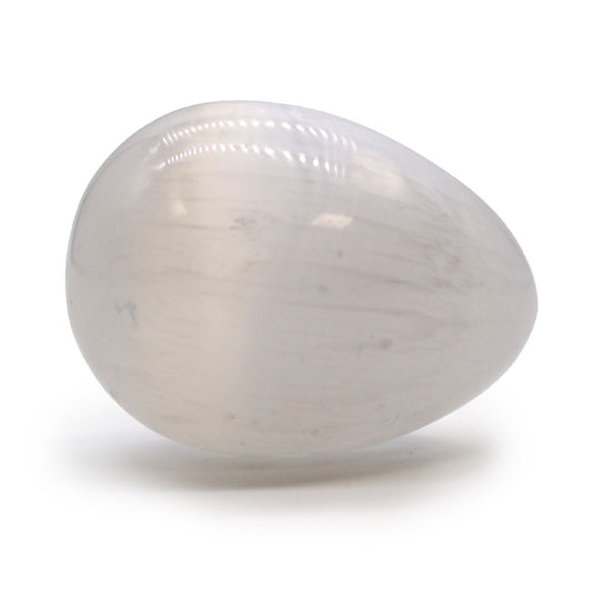 Smooth, egg-shaped white selenite crystal with a milky, iridescent finish reflecting light.