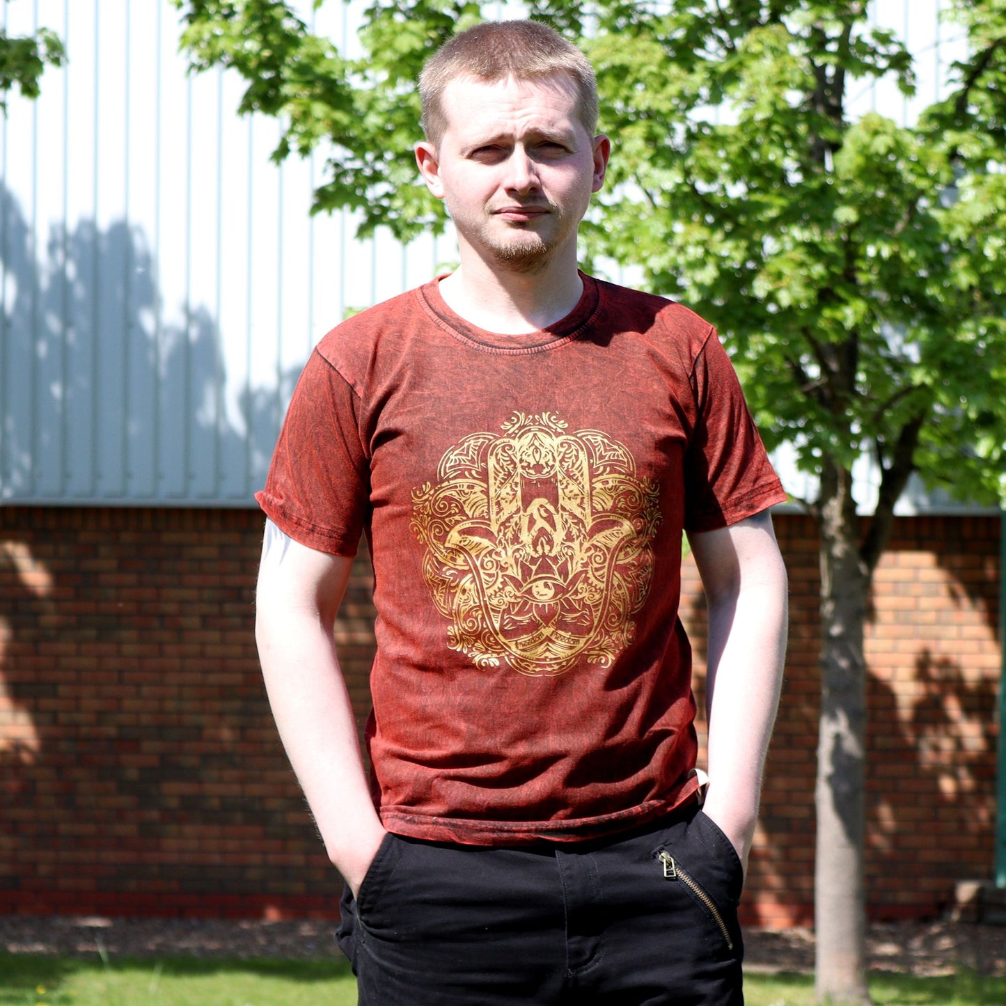 Maroon stonewashed t-shirt featuring a central Hamsa hand symbol in a vintage nomad style.