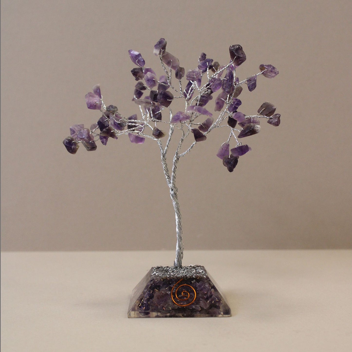 Beautiful Amethyst gemstone tree with purple crystal leaves on a wire frame standing on a circular orgonite base.