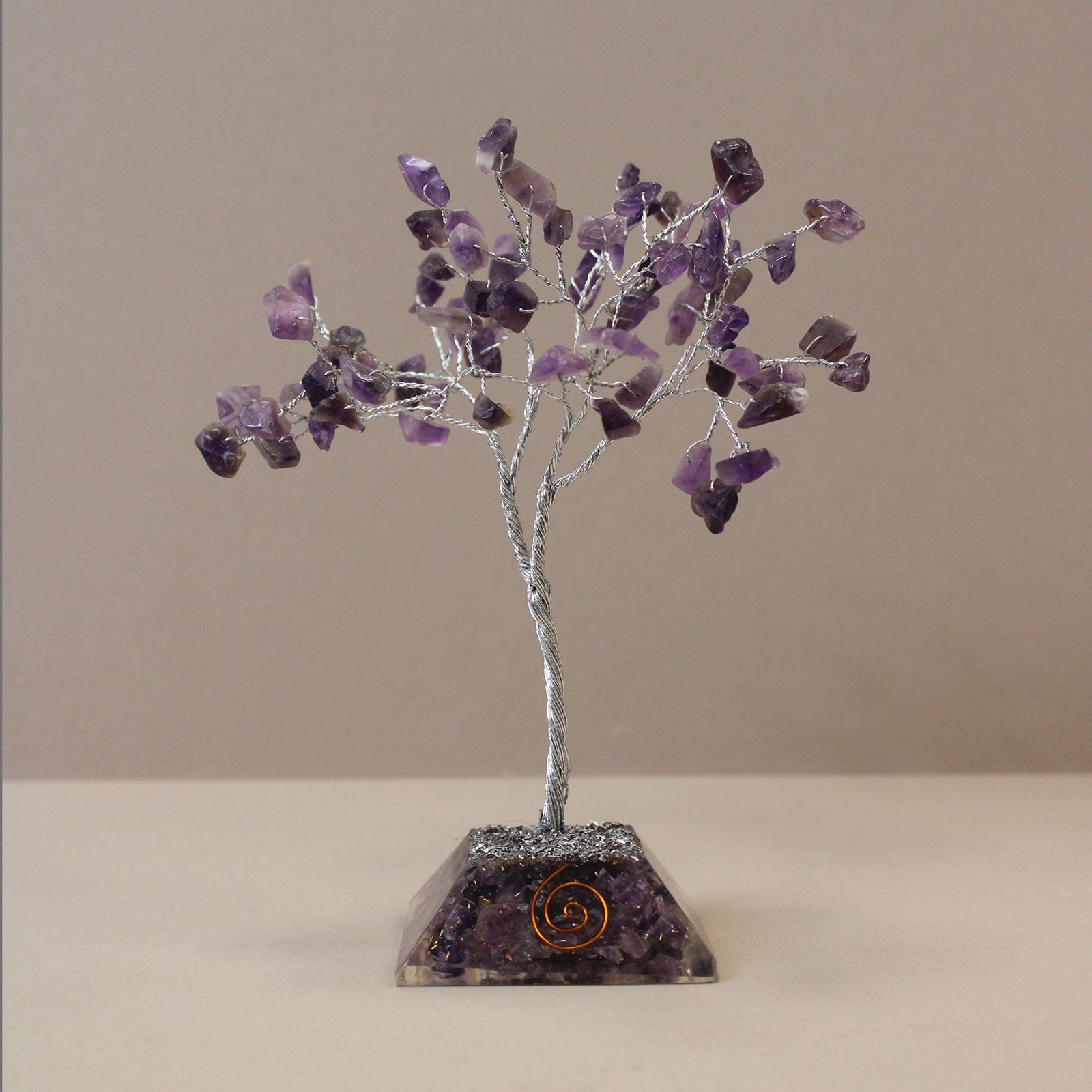 Beautiful Amethyst gemstone tree with purple crystal leaves on a wire frame standing on a circular orgonite base.