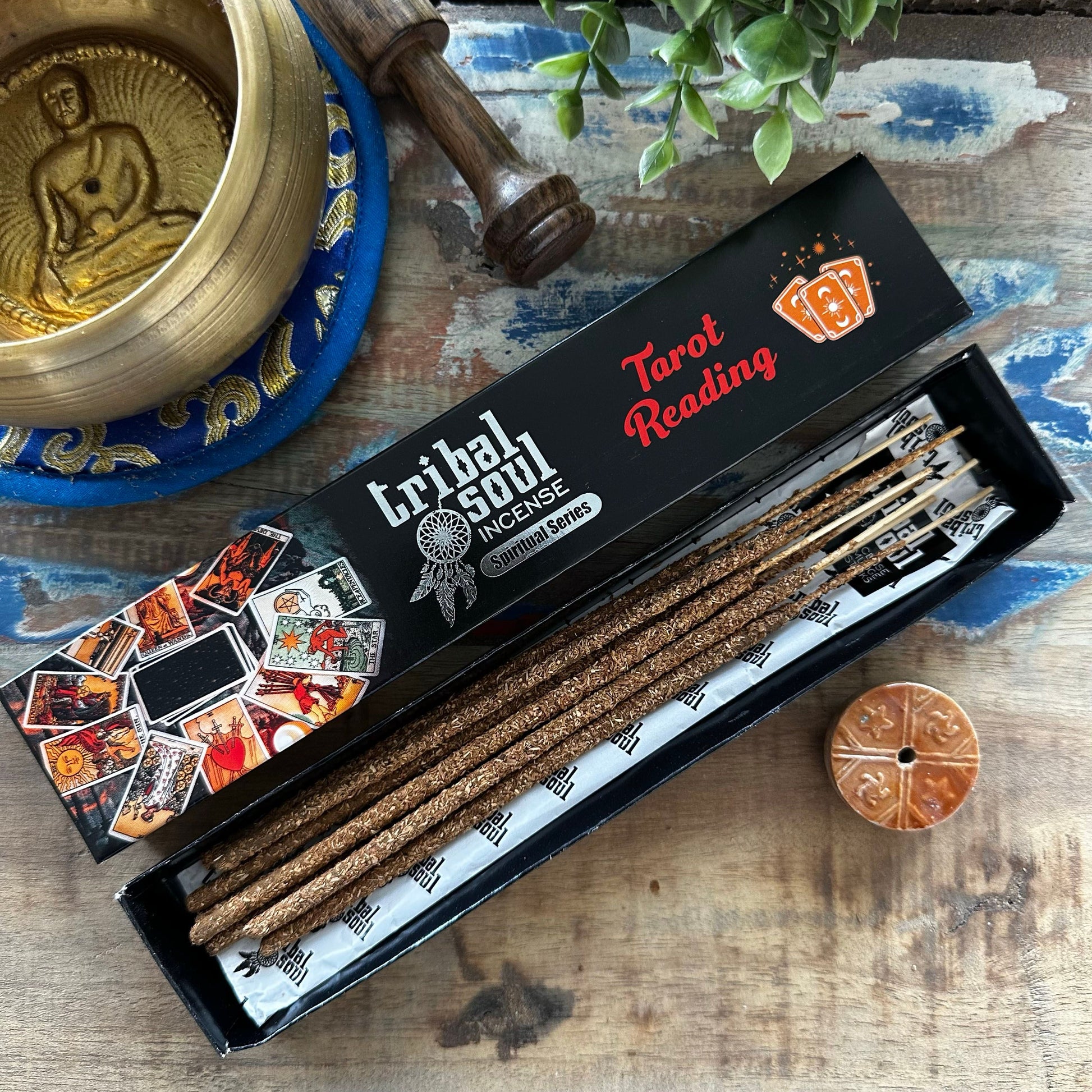 Hand-rolled incense sticks with a minimalist ceramic holder on a wooden surface for spiritual rituals.