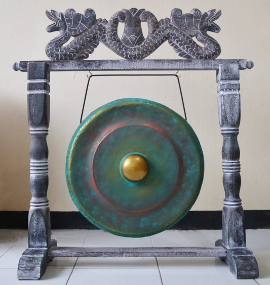 Small 25cm greenwash healing gong hanging from an intricately carved dark wooden stand.