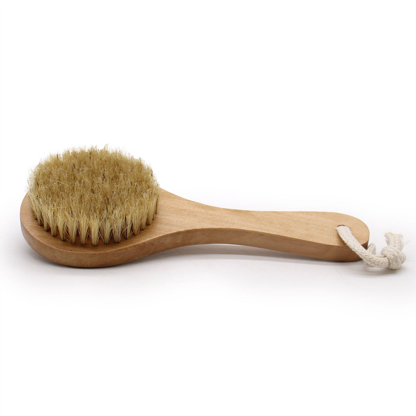 Close-up of a natural bristle body scrub brush with a short wooden handle for easy exfoliation.