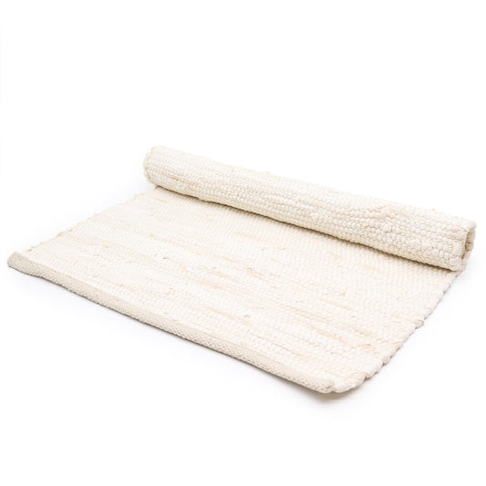 Large cream-coloured hand-woven cotton rug with a minimalist textured finish and fringed edges.