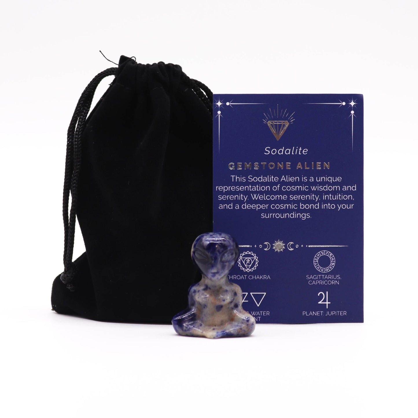 Small carved gemstone alien figure made from blue and white speckled sodalite stone.