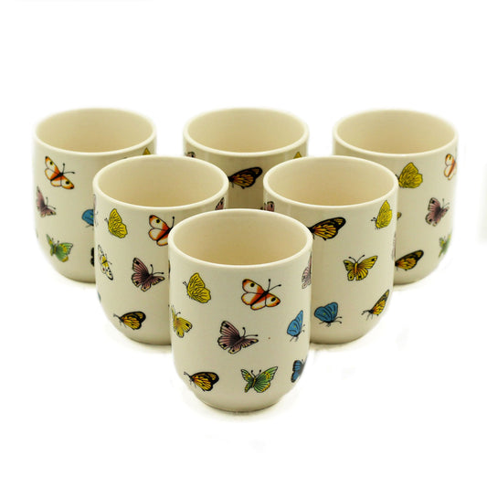 Set of petite handleless ceramic tea cups decorated with a delicate butterfly design.