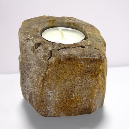 Hand-carved petrified wood tealight holder with a natural rustic texture and earthy tones on a wooden surface.