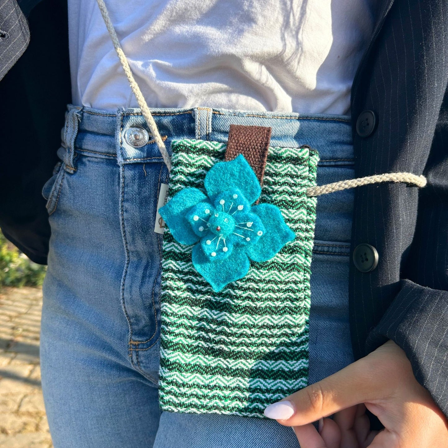 Handmade green and white striped fabric mobile phone holder bag with a decorative green flower embellishment.