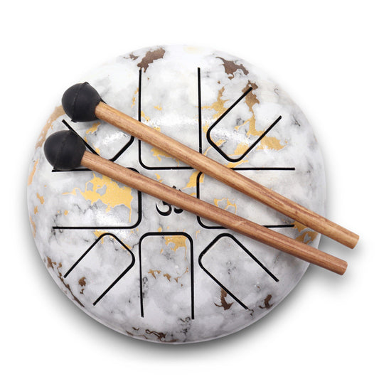 A medium-sized steel tongue drum with a white and grey marble-effect finish, featuring gold accents on the musical tongues.