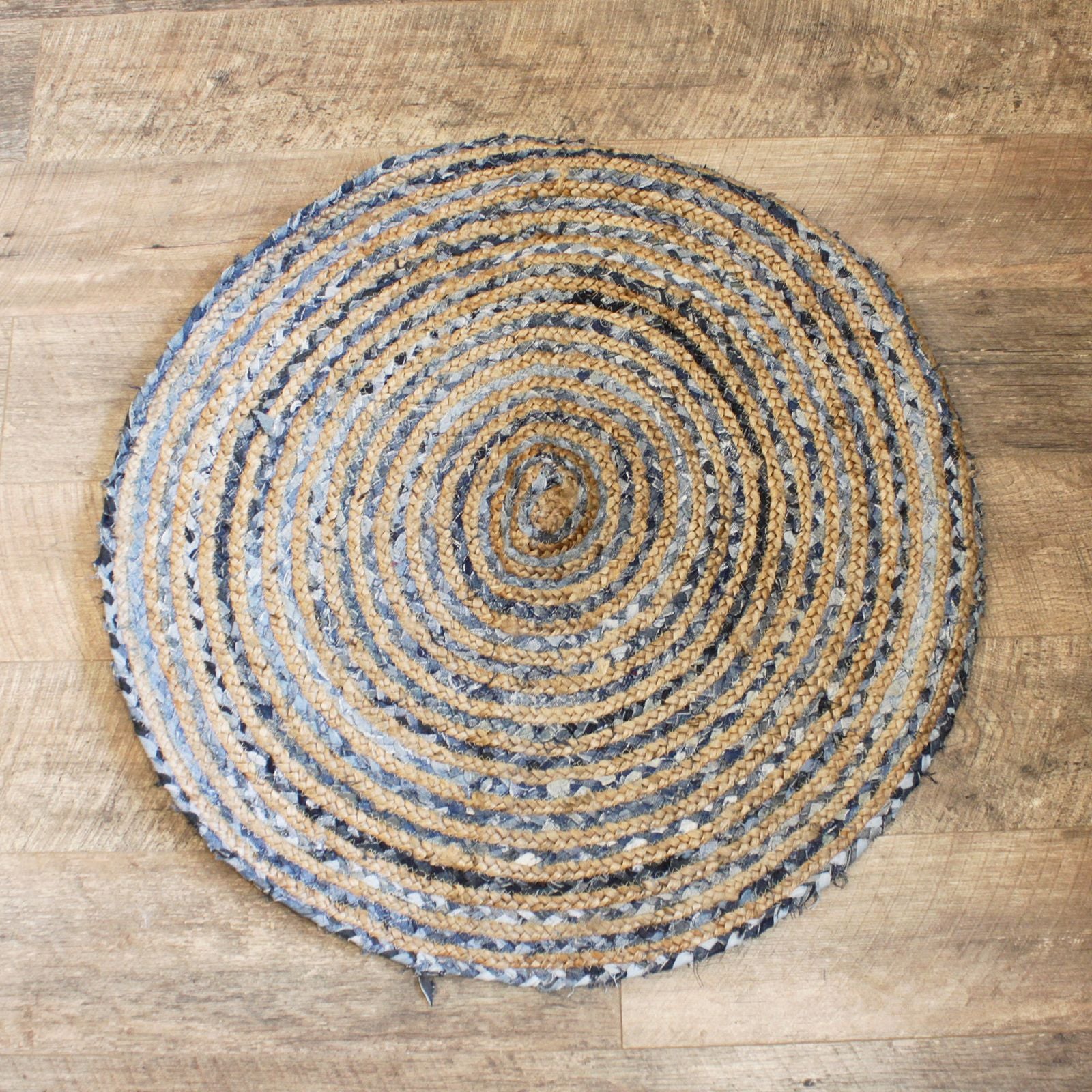 Handcrafted 90cm round rug made from natural jute and blue recycled denim off-cuts in a circular woven pattern.