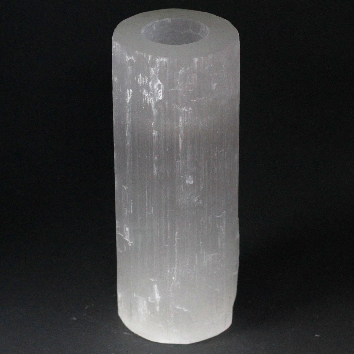 Tall translucent white selenite cylinder candle holder with natural rough edges and a smooth polished finish.
