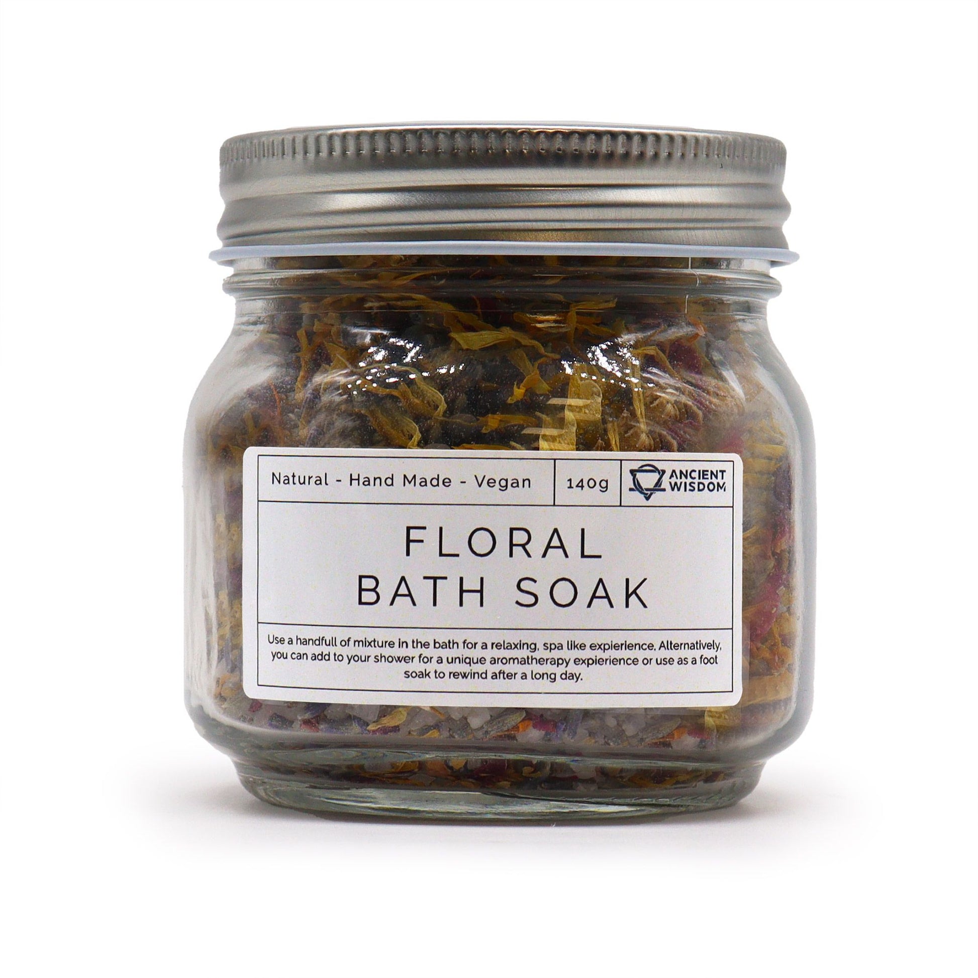 Clear glass jar filled with a colorful blend of dried flower petals and premium sea salt for a natural bath soak.