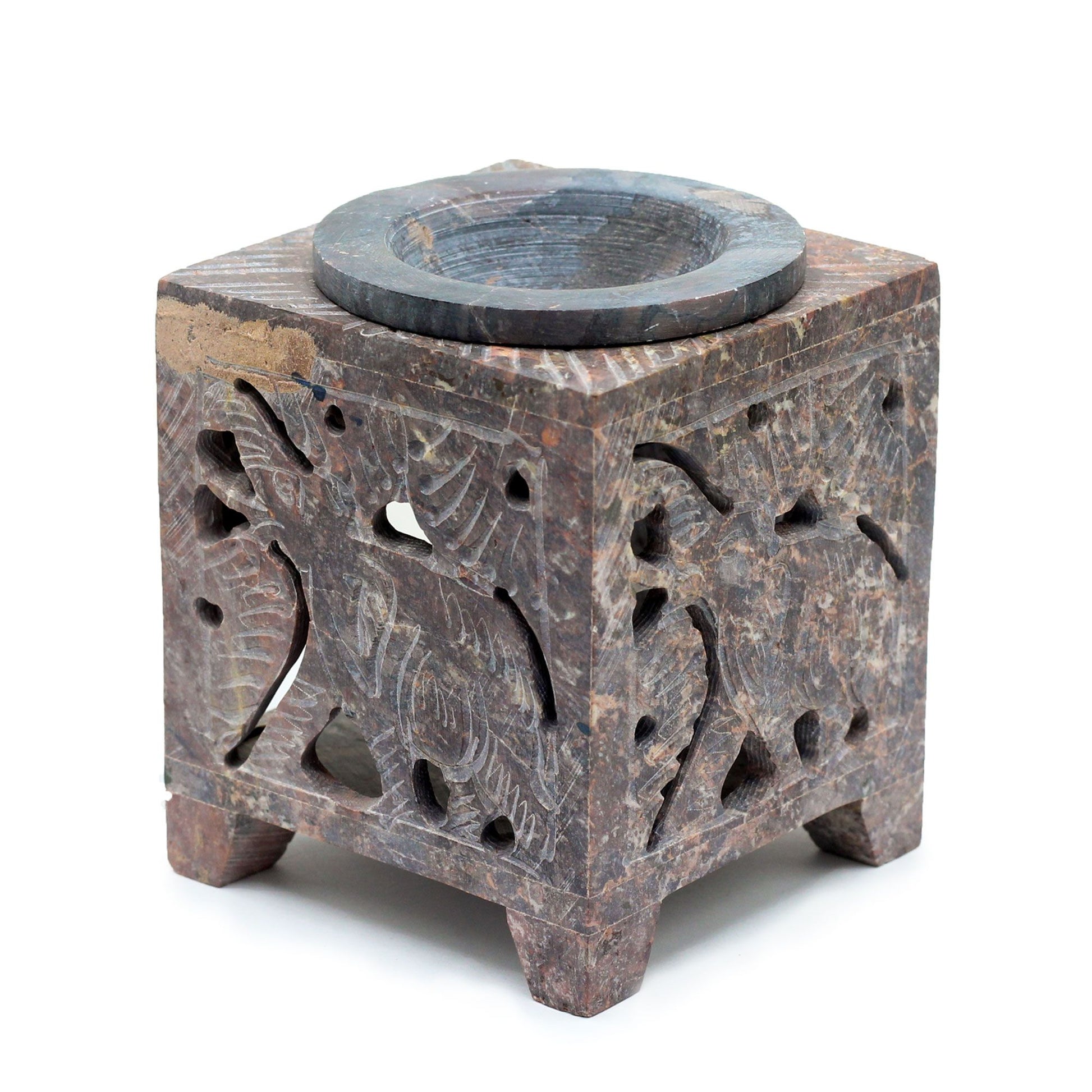 Square natural soapstone oil burner featuring intricate elephant carvings on each side with earthy rustic tones.