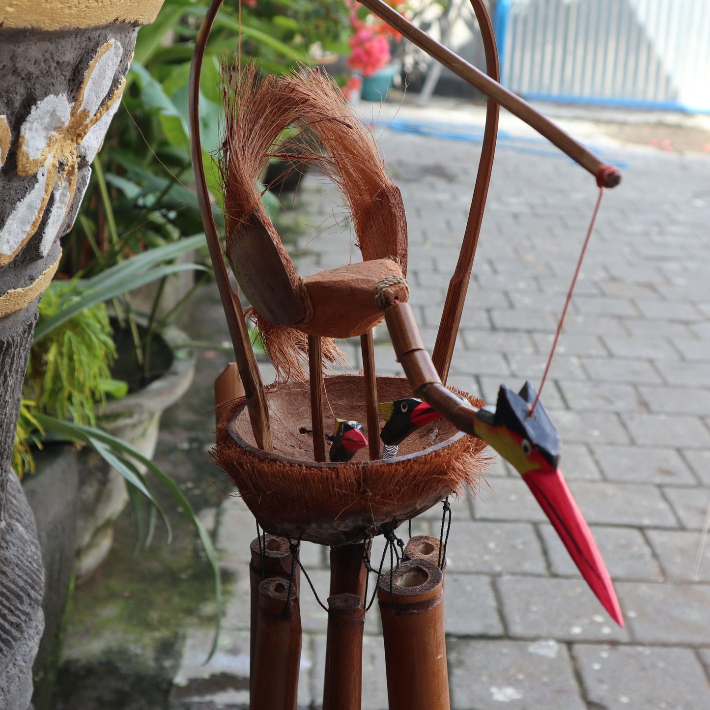 Handcrafted natural finish bamboo windchime featuring a carved mother bird and chicks with hanging bamboo tubes.