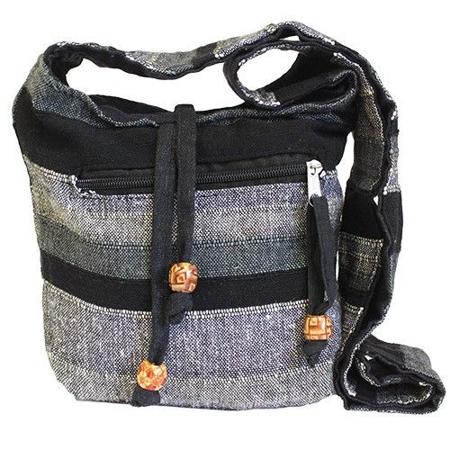 Textured grey fabric sling bag with a wide shoulder strap and functional front pockets for travel.