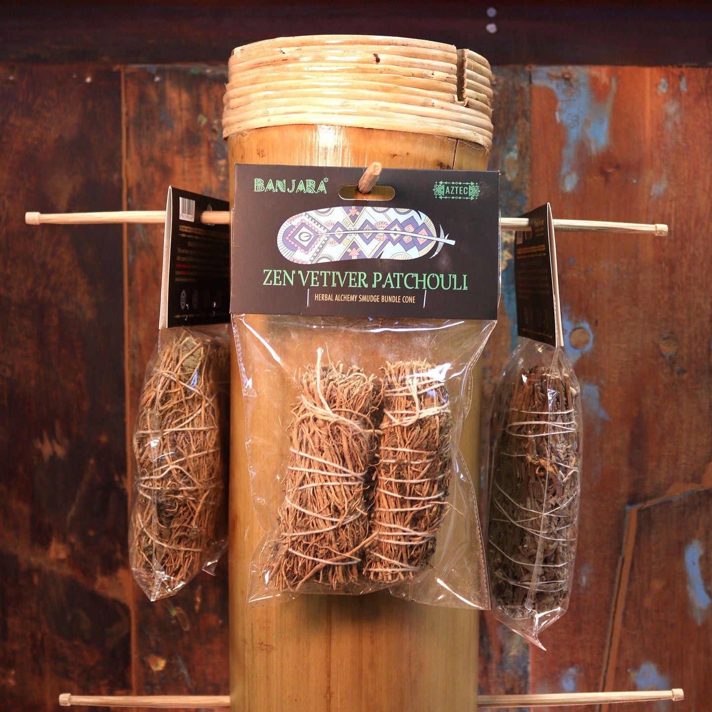 Handcrafted smudge stick bundle made of dried botanical herbs including vetiver and patchouli leaves.