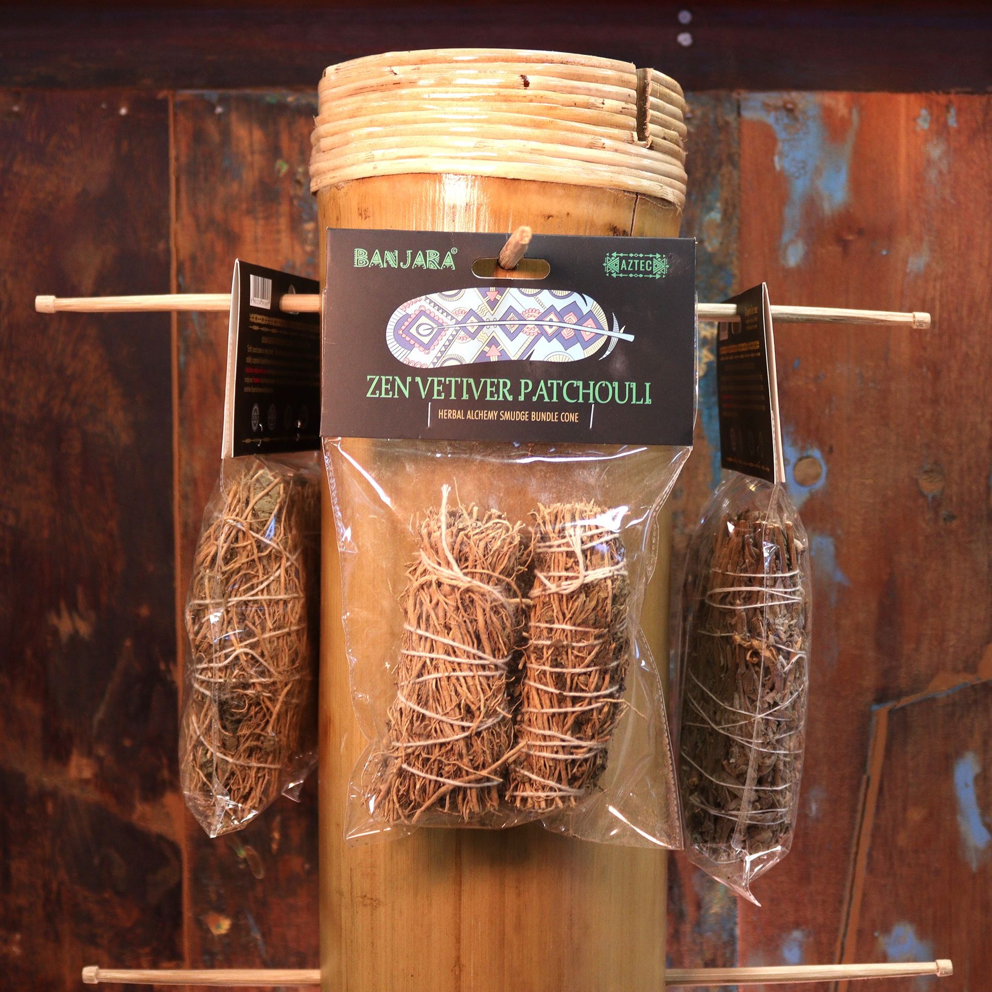 Handcrafted smudge stick bundle made of dried botanical herbs including vetiver and patchouli leaves.