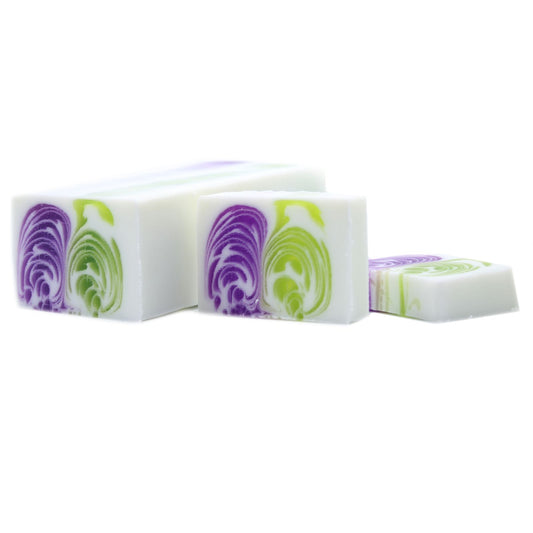 Large artisanal soap loaf with a vibrant purple dewberry hue and textured handcrafted top.