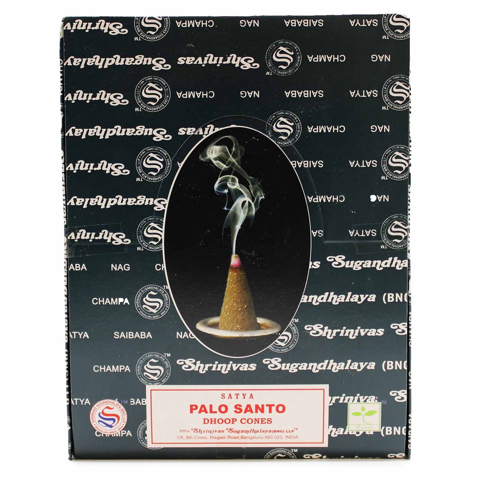 Small dark brown conical dhoop incense cones made from palo santo wood on a simple heatproof ceramic dish.