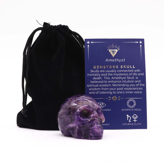 Detailed hand-carved purple amethyst gemstone skull with natural crystalline inclusions and a polished finish.