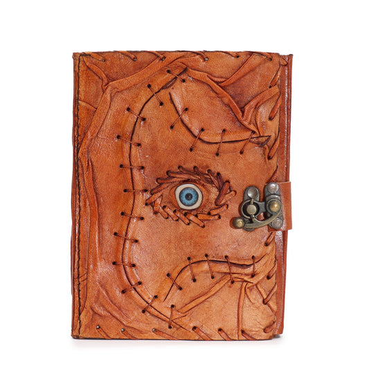 Tan leather notebook with a central evil eye design and textured deckle-edge paper pages.
