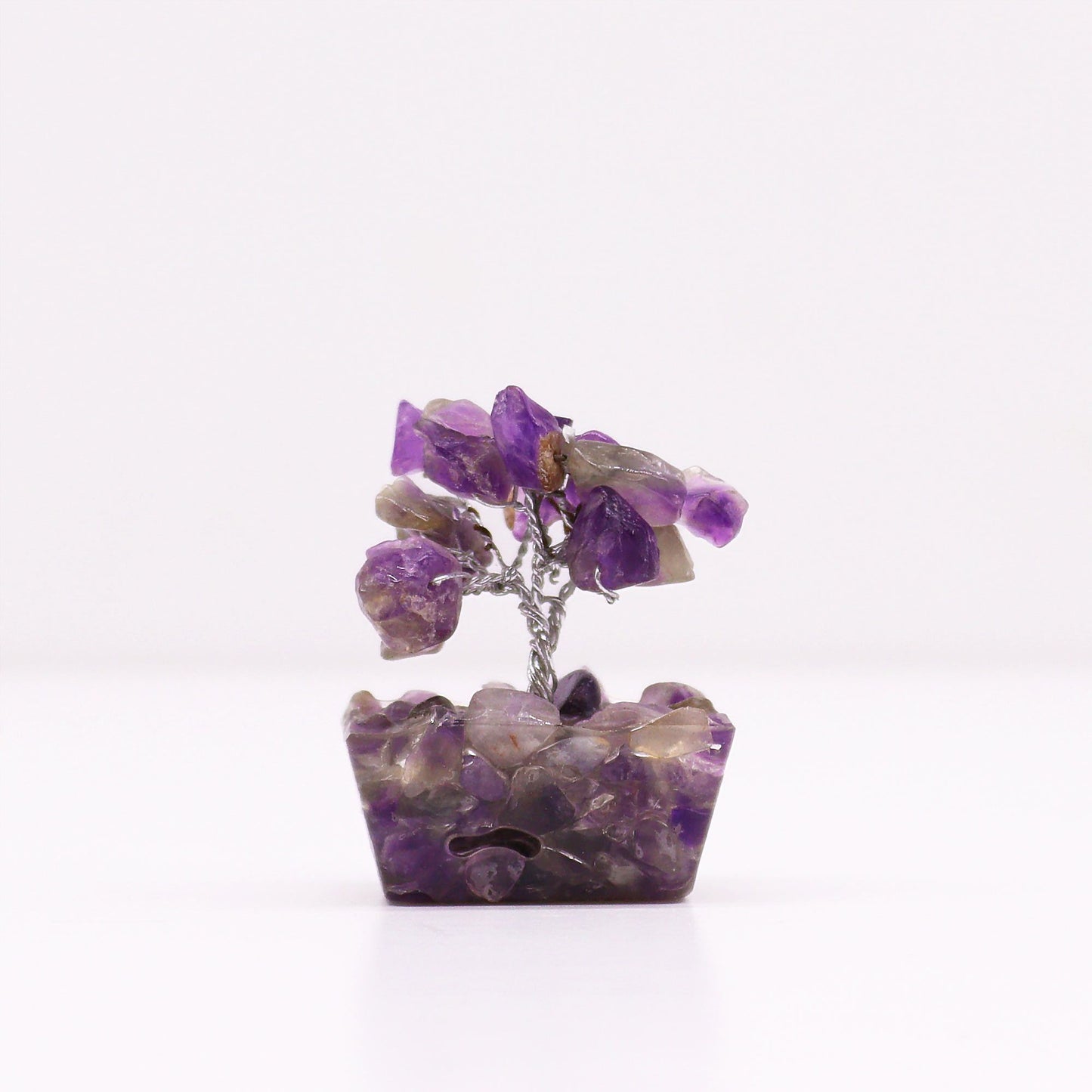 Small amethyst crystal gemstone tree with wire branches set on a pyramid-shaped orgonite base with gold flakes.
