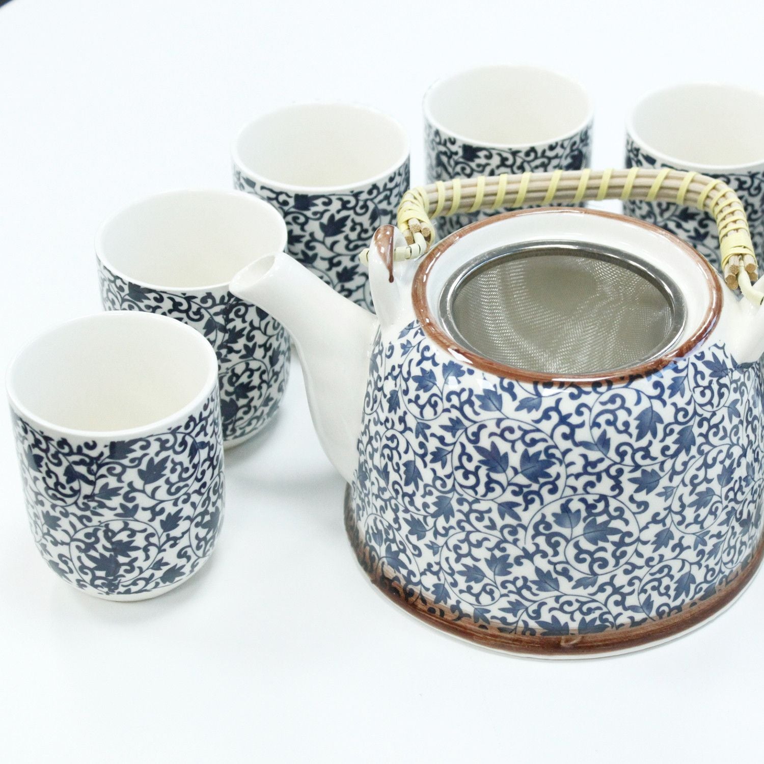 Ceramic herbal teapot set featuring a traditional blue pattern with a matching lid and six small handleless tea cups.