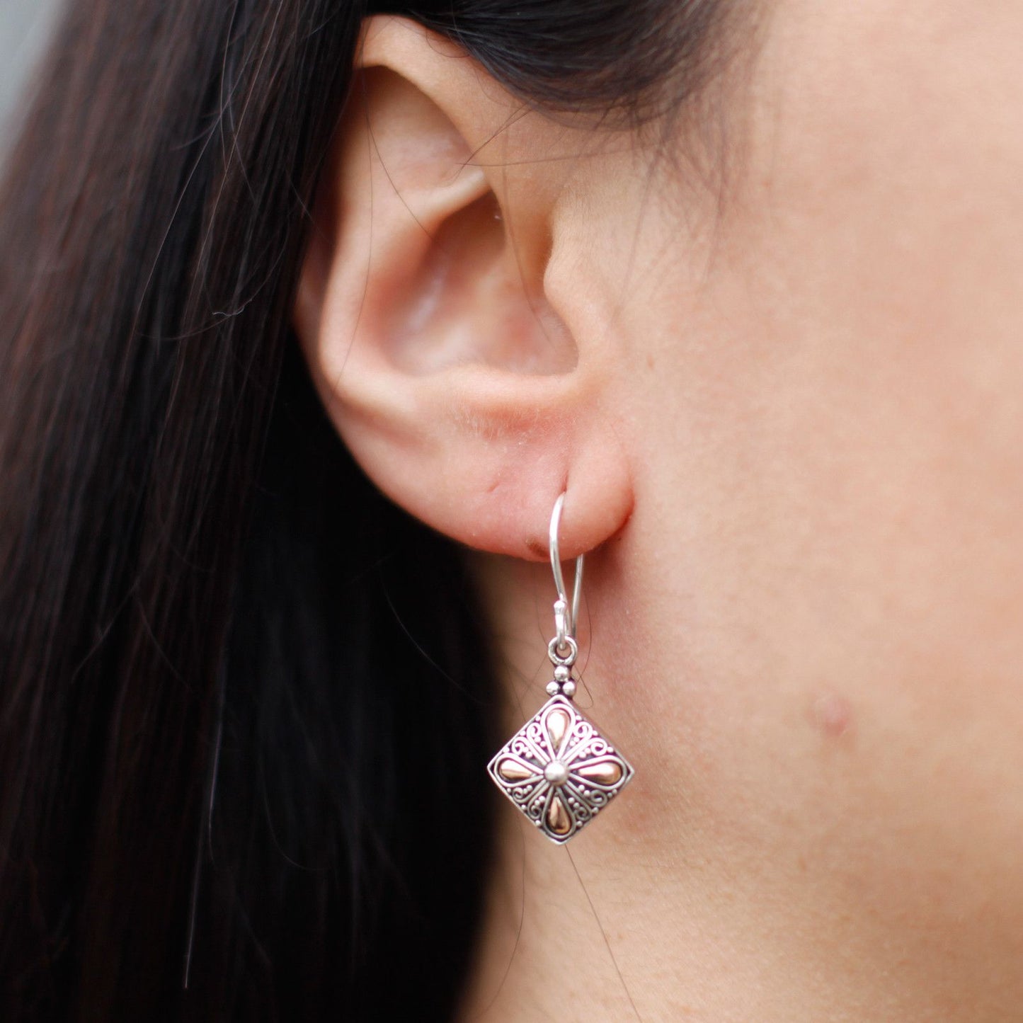 Elegant mixed metal drop earrings featuring a square design in silver and gold tones.
