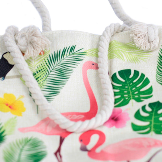 Large canvas beach tote bag with pink flamingo and green tropical leaf print featuring thick white rope handles.